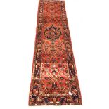 Persian Hamadan runner rug, central medallion on red field, enclosed by guarded border, 370cm x 105c