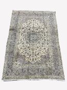 Persian ivory ground rug, central star motif enclosed by interlaced foliate, with multi line border,