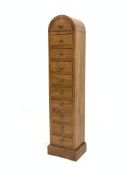 20th century hardwood tall multi drawer chest, with arched top and fitted with ten drawers, plinth b
