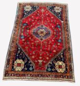 Persian Qashqai ground rug, with lozenge medallion on red field decorated with stylised animals and