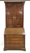 Georgian oak bureau bookcase, two arched fielded panelled doors enclosing four adjustable shelves, e