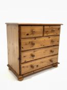 Modern polished pine chest fitted with two short and three long drawers, raised on turned bun suppor