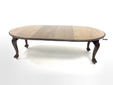 Early 20th century mahogany extending dining table, the oval top with floral edging over acanthus ca