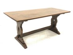 Distressed oak refectory dining table, with rectangular top raised on shaped and pierced panel end s