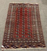 Persian Afghan design Bokhara ground rug, with repeating gul motif on red field, enclosed by multi l