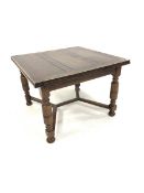 Early 20th century oak duo draw leaf dining table, top raised on turned supports united by castors,