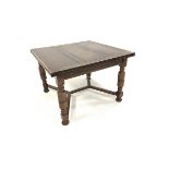 Early 20th century oak duo draw leaf dining table, top raised on turned supports united by castors,