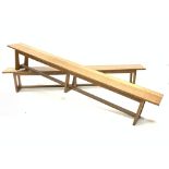 Large pair of 20th century oak benches, each raised on three supports united by stretchers, W290cm,