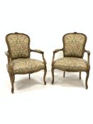 Pair of French style beech upholstered open salon armchairs, floral carved cresting rail, incised an