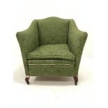 Edwardian easy armchair of square form, upholstered in green Damask, with squab cushion, raised on s