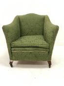 Edwardian easy armchair of square form, upholstered in green Damask, with squab cushion, raised on s