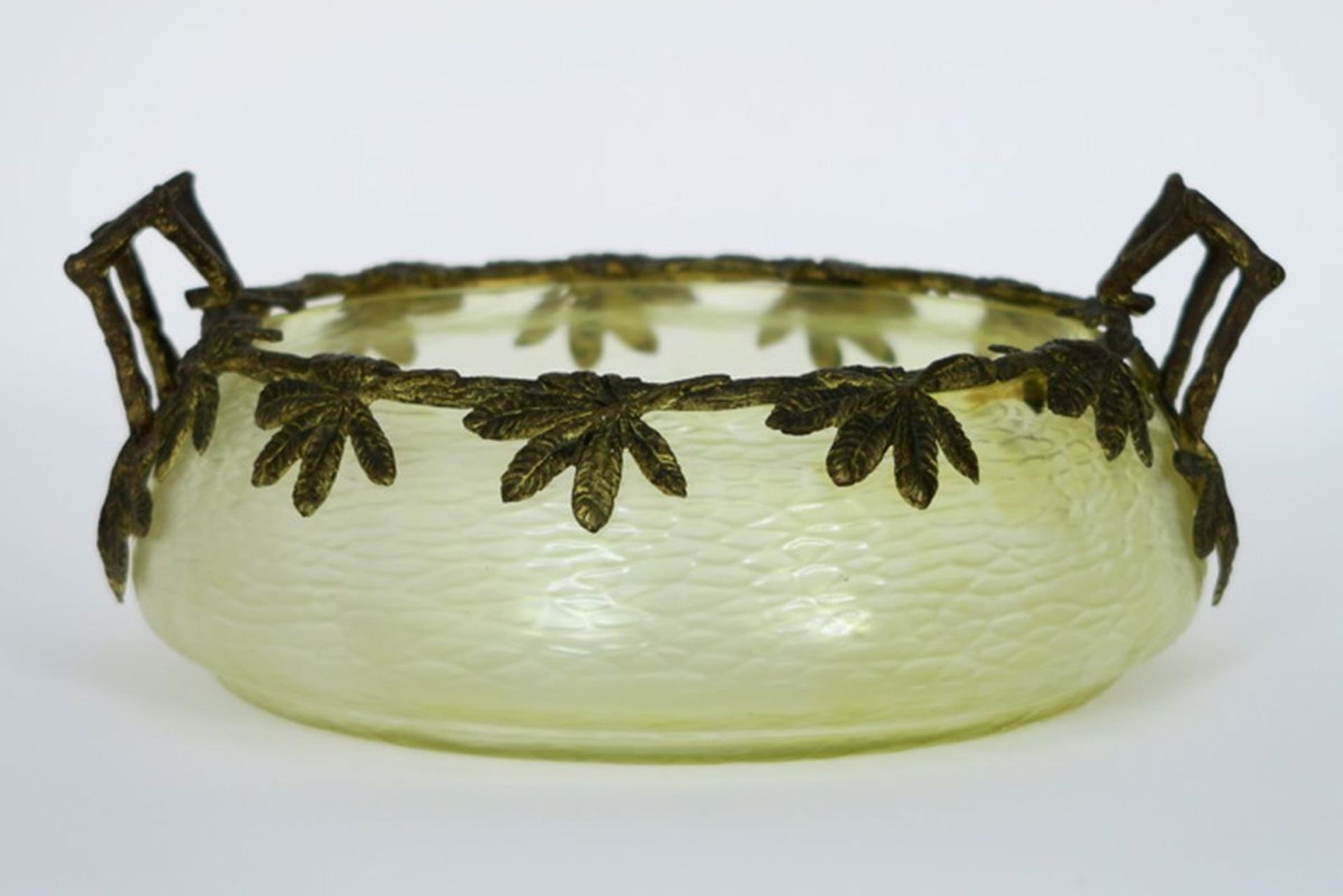 Art Nouveau bowl in glass with iridiscent color and with a mounting in guilded bronze [...]