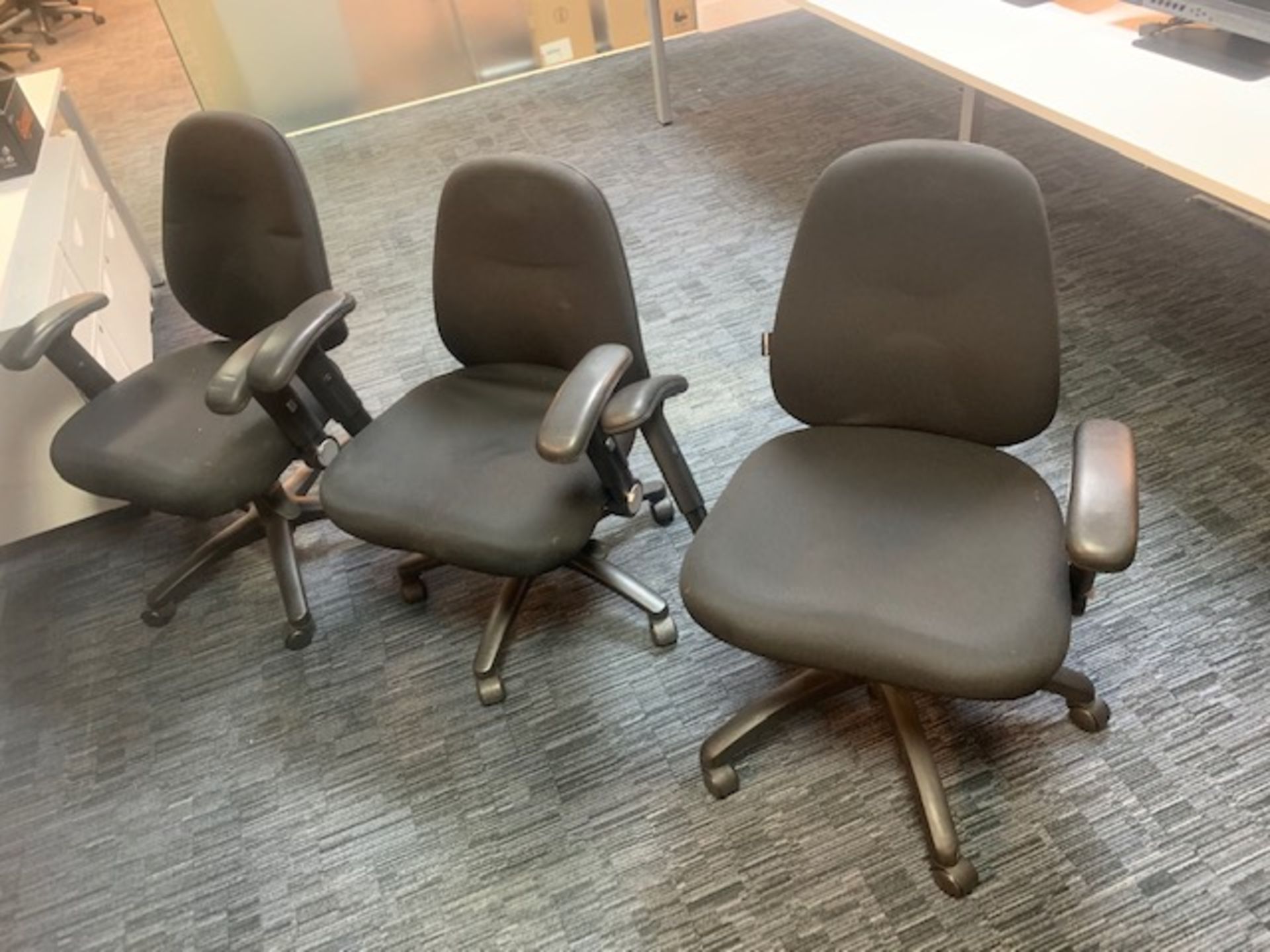 Three black cloth swivel & tilt office chairs