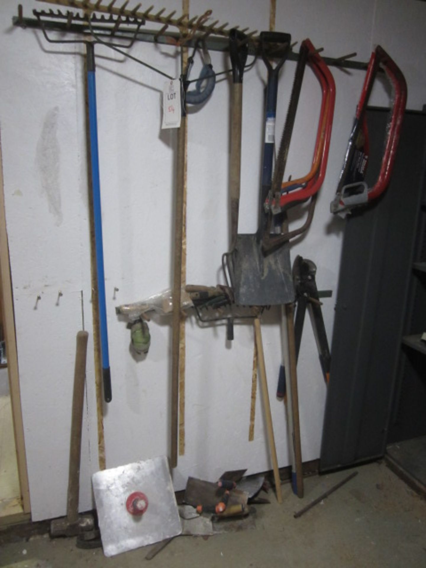 Assorted tools including forks, hoe, sledge hammer, trowels, shovel, rake, loppers, saws, spill kit.