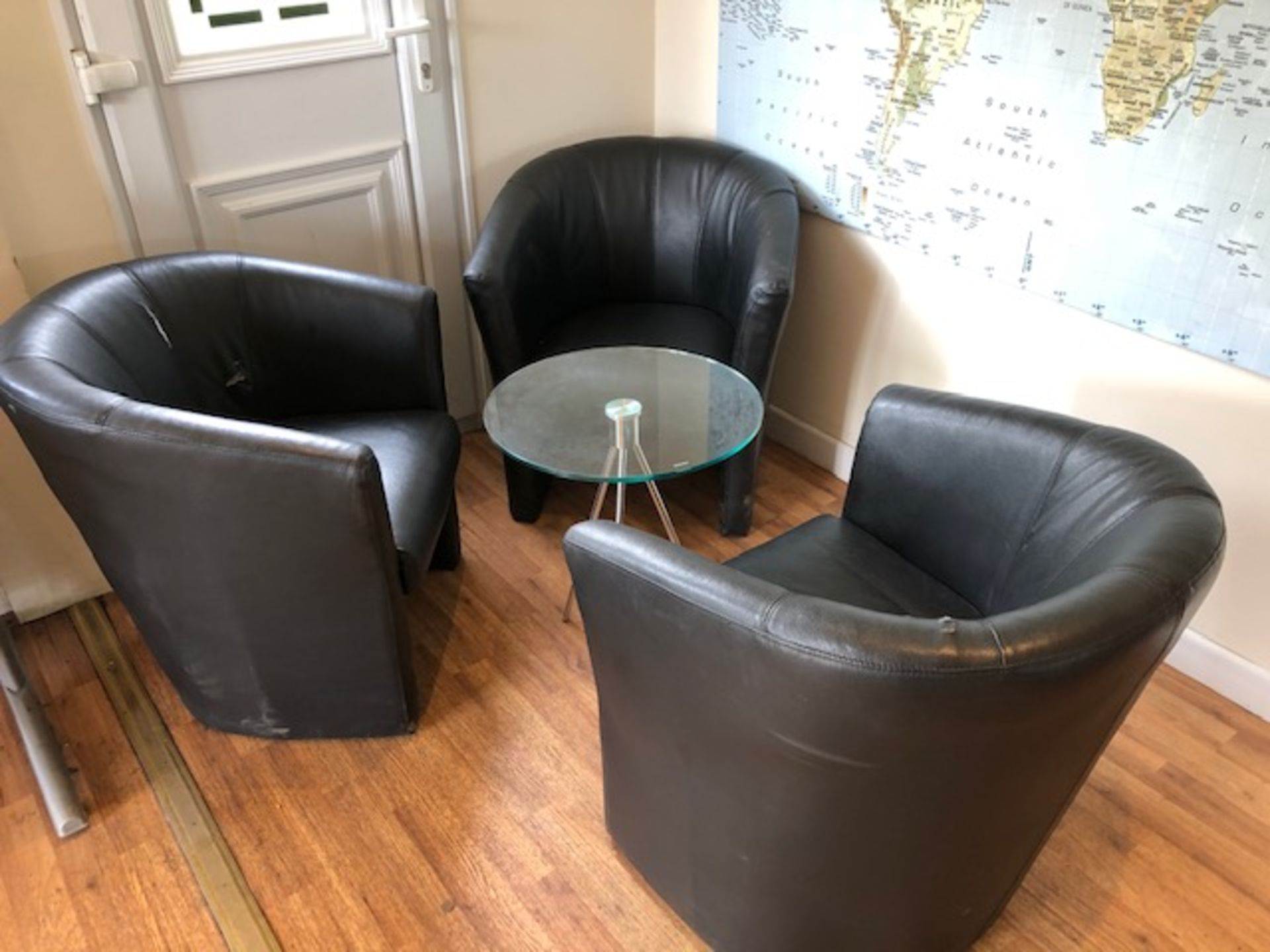 Three brown leatherette tub chairs (two with tears) and a 500mm dia chrome framed glass top coffee