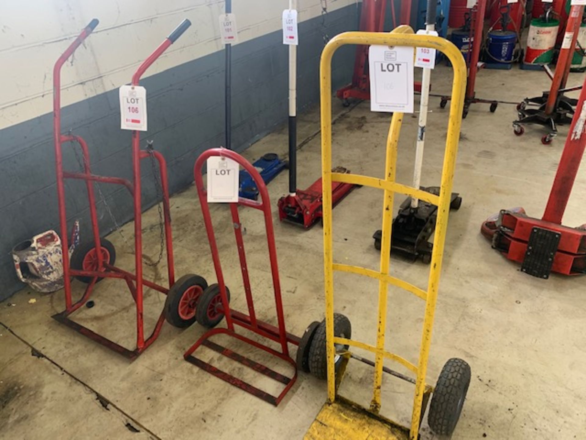 Two bottle trolleys and a sack barrow