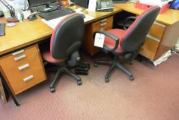 Two dark wood multi drawer desks and two red cloth upholstered swivel chairs