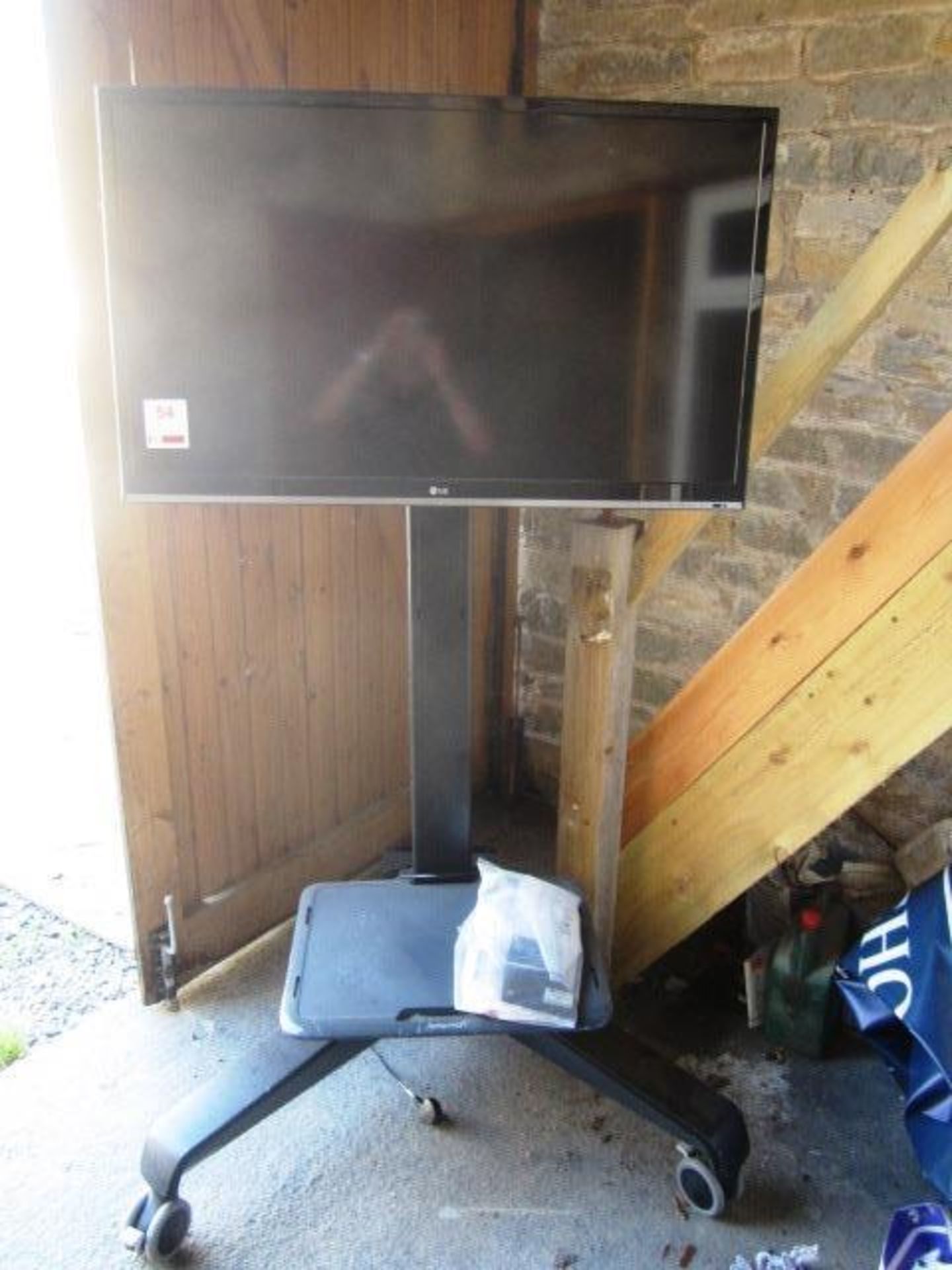 LG 42" flat screen TV, model 42LS5600ZC mounted on mobile stand - unsure of working condition,