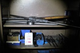 Two shelves of assorted pipe threaders and associated attachments