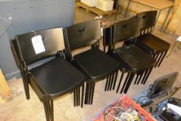Sixteen black plastic stacking chairs