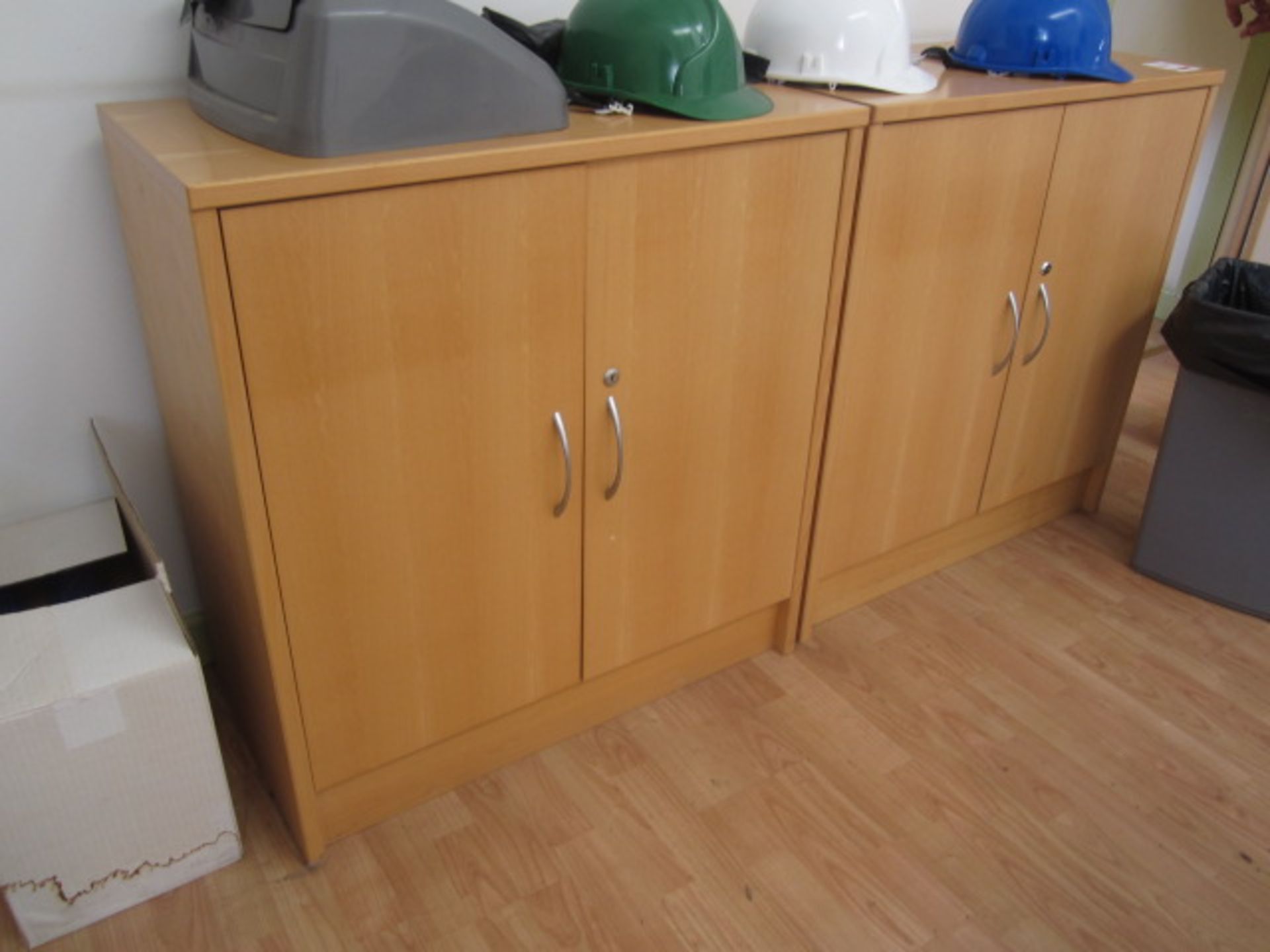 Two light wood twin door cabinets