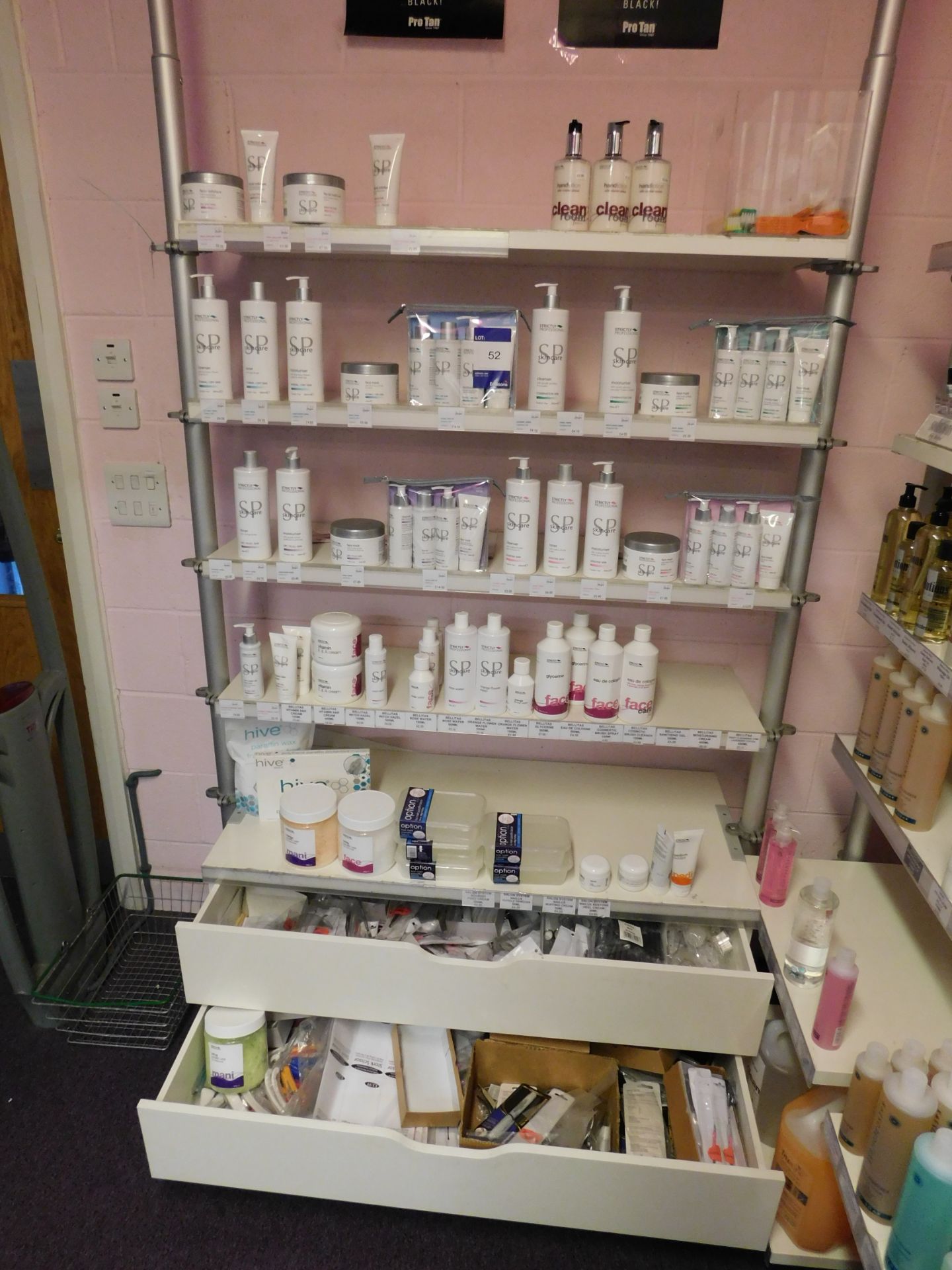 Assortment of beauty treatment products to shelving, including paraffin wax, skin care cleanser, eye