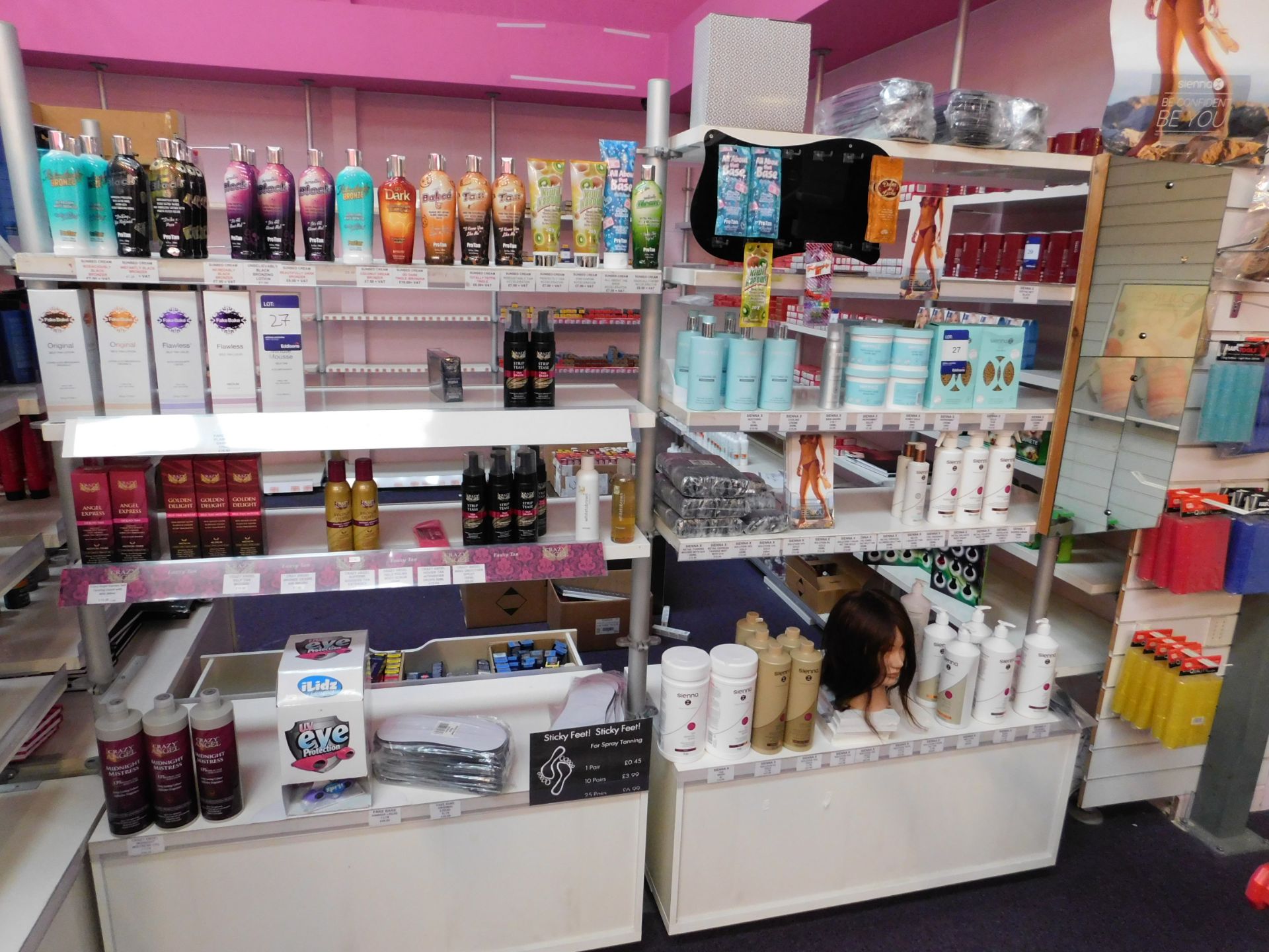 2 x Bays of shop display shelving and contents, including assortment of tanning products (tan