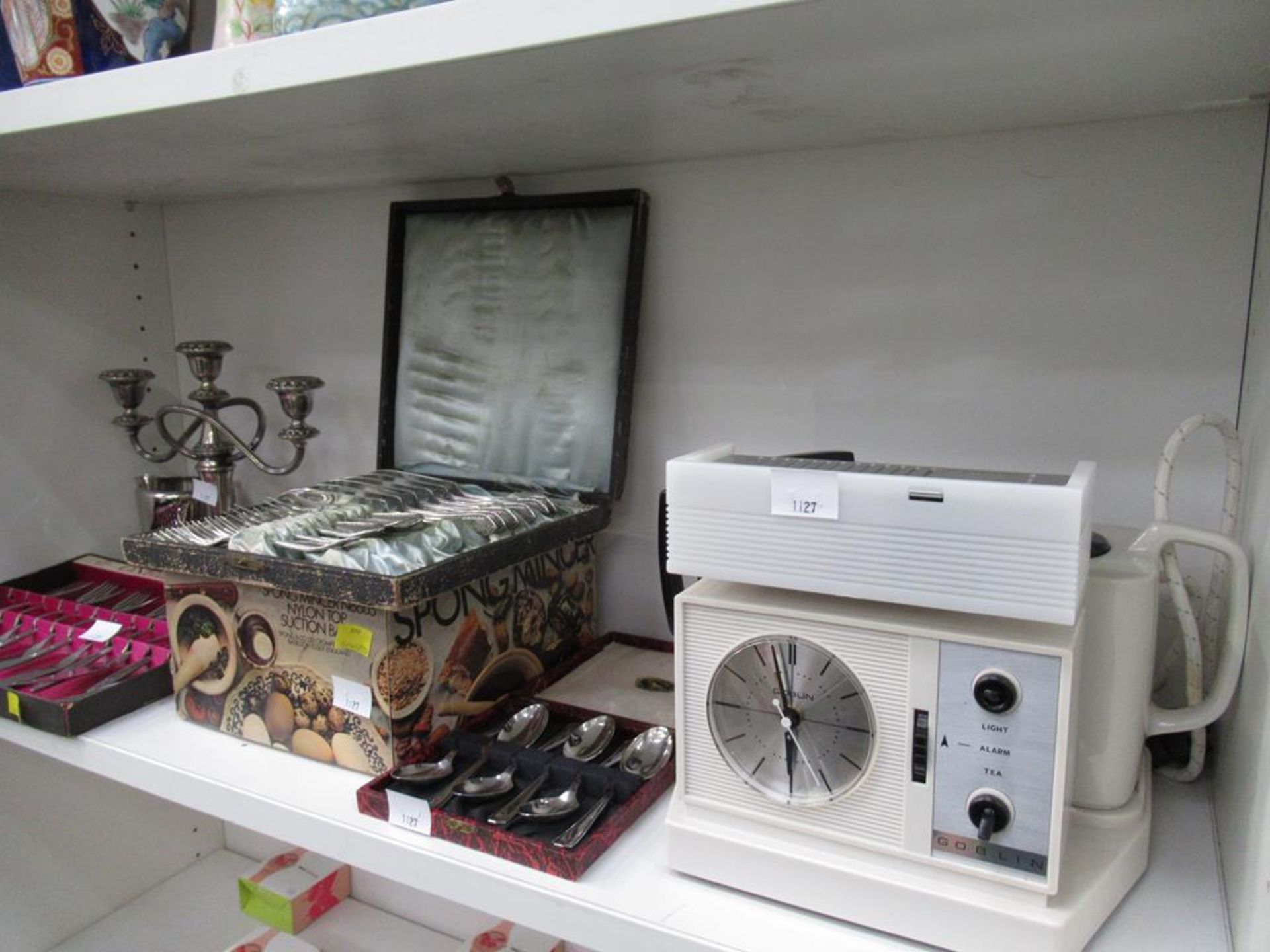 A Shelf containing Boxed Cutlery etc.