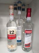 Three bottles of Amor D'ua Bianca Fine Grappa, a bottle of Iseo Sambuca and a bottle of '12 Ouzo'