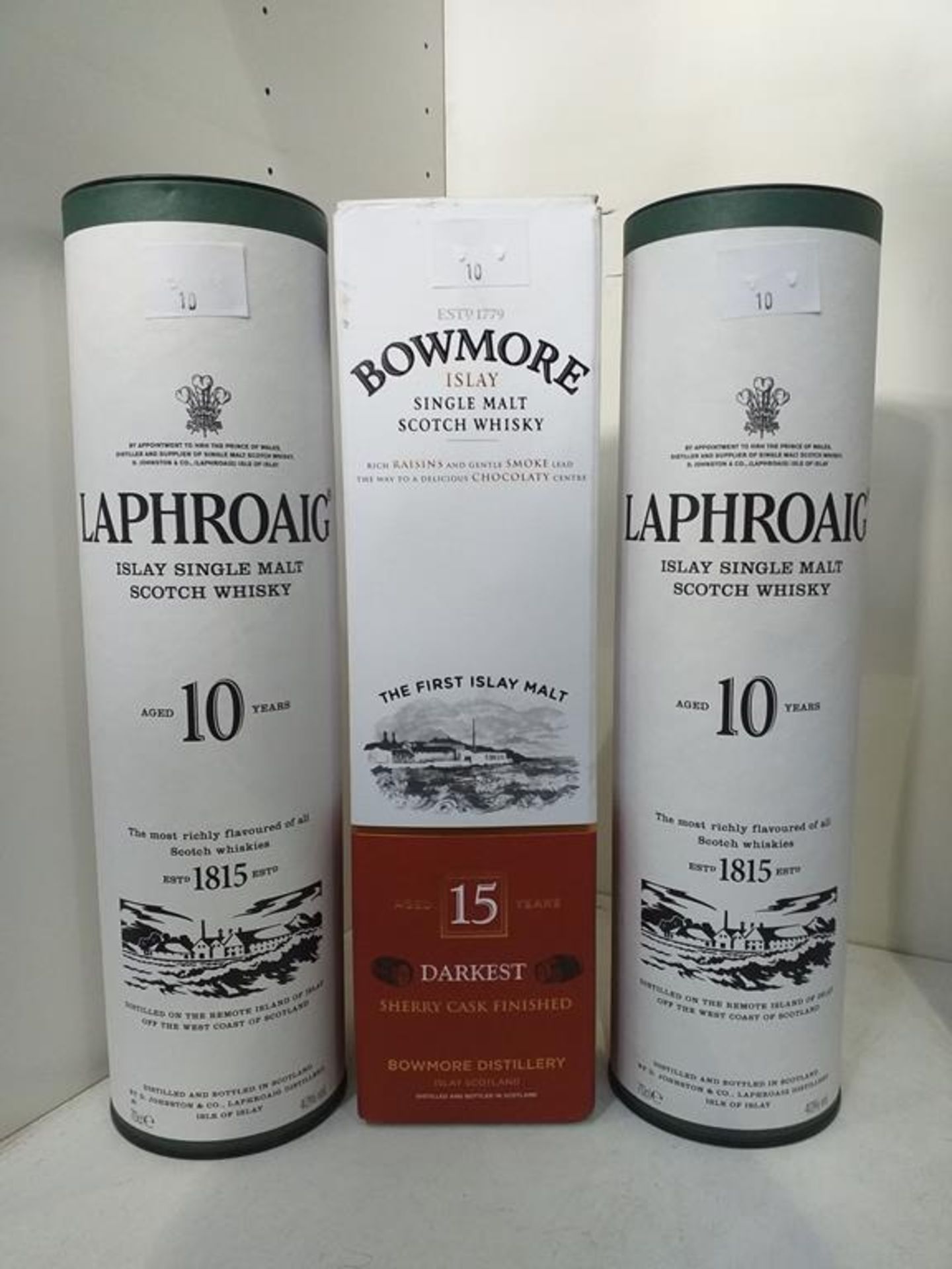 Two bottles of Laphroaig Islay Single Malt Scotch Whisky and a bottle of Bowmore Islay Single Malt