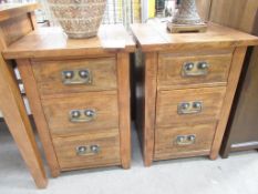 A pair of wooden effect three drawer bedside cabinets