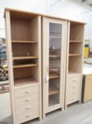 Two wooden effect bookcases on four drawers together with a glass door fronted display cabinet/bookc