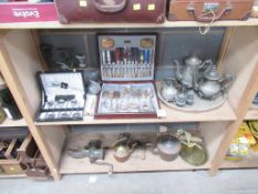 Two shelves of tableware including cutlery, plated ware, beaten jugs/kettles etc