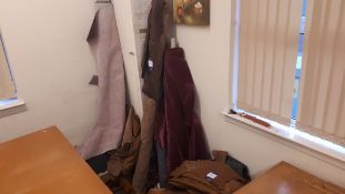 Large quantity of fabric off-cuts, to wall and under table, including leather off-cuts