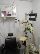 Topcon stand unit with refractor and chair and an eye test wall chart cabinet