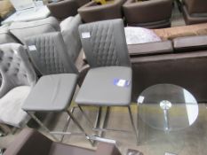 A pair of grey stools with glass table