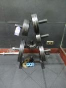 18 various weight lifting plates on rack with lifting bar and clamps