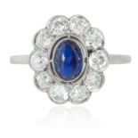 SAPPHIRE AND DIAMOND CLUSTER RING set with a cabochon sapphire in a border of old cut diamonds, size