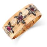 A RUBY AND DIAMOND BANGLE set with cabochon garnets and rose cut diamonds in star motif, 6cm inner