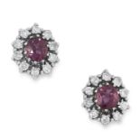 A PAIR OF RUBY AND DIAMOND CLUSTER STUD EARRINGS each set with an oval cut ruby encircled by round