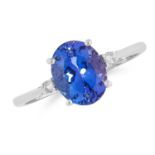 A TANZANITE AND DIAMOND RING in 18ct white gold, set with an oval cut tanzanite between two round