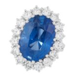 A CEYLON NO HEAT SAPPHIRE AND DIAMOND CLUSTER RING set with an oval cut sapphire of 13.73 carats