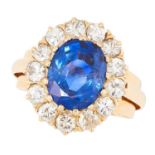 A BURMA NO HEAT SAPPHIRE AND DIAMOND CLUSTER RING set with an oval cut sapphire of 4.50 carats in