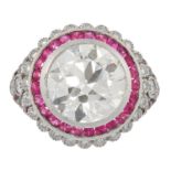 A DIAMOND AND RUBY DRESS RING in Art Deco design, set with a round cut diamond of 4.85 carats in a