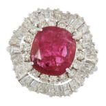 A RUBY AND DIAMOND CLUSTER RING set with a oval cushion cut ruby of 3.20 carats in a border of round