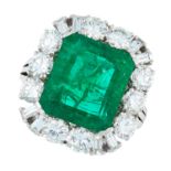 AN EMERALD AND DIAMOND DRESS RING in 18ct white gold, set with an emerald cut emerald of 7.70