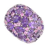 AN AMETHYST AND PINK SAPPHIRE BOMBE RING set with oval brilliant cut amethysts and round brilliant