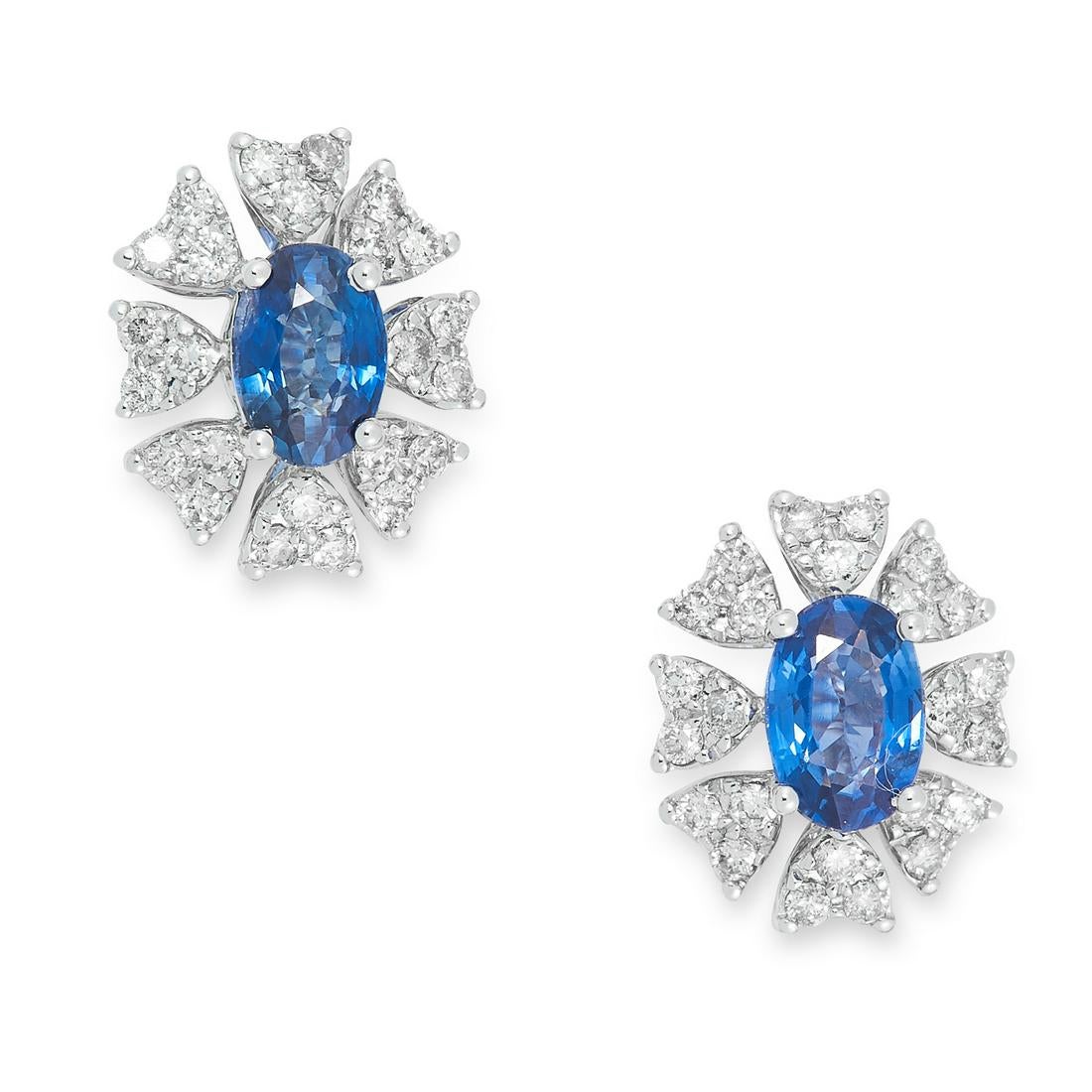 A PAIR OF SAPPHIRE AND DIAMOND CLUSTER EARRINGS set with an oval modern brilliant cut sapphire in