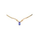 TANZANITE AND DIAMOND PENDANT NECKLACE set with a pear cut tanzanite between two round cut diamonds,