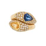 A BLUE SAPPHIRE, YELLOW SAPPHIRE AND DIAMOND CROSSOVER RING set with a fancy cut yellow sapphire,